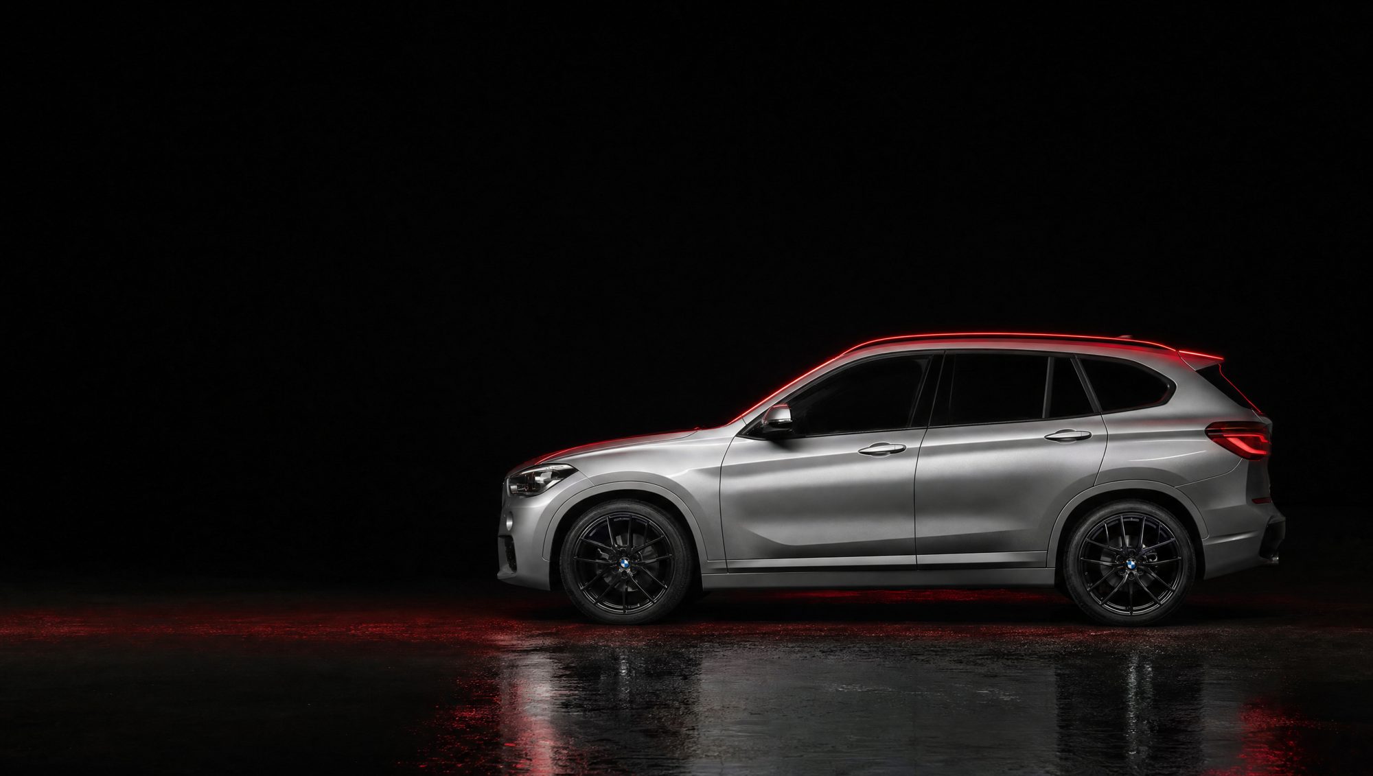 BMW X1 prata em estúdio escuro com luz vermelha
